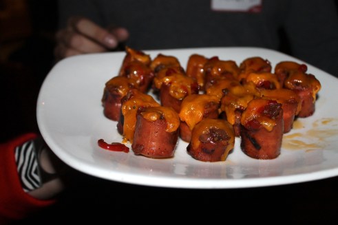 Rev Dog - beef hot dog, guacamolesweet & sour peppers,  cheddar cheese, carmelized onions